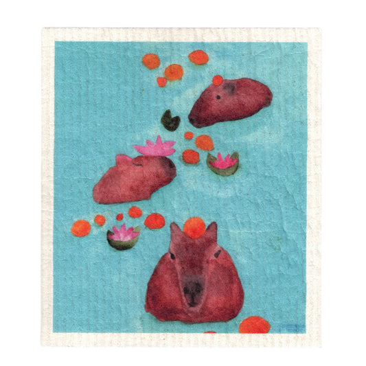 A white, textured Swedish dish cloth featuring three capybaras, swimming in light blue water among oranges and lotuses.