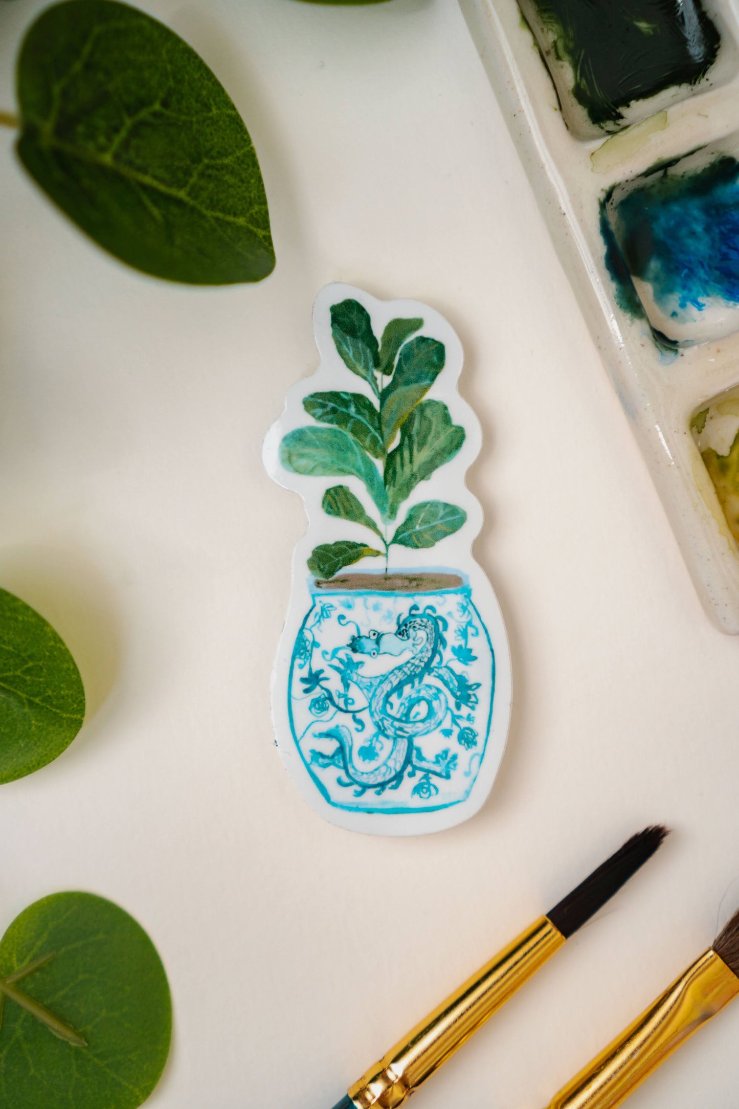 A sticker of a fiddle-leaf fig plant in a blue and white porcelain vase, decorated with a dragon.