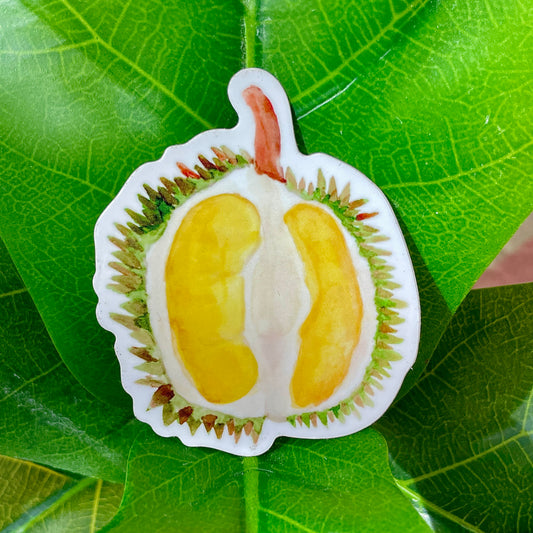 A white, yellow, and green sticker of half a cut-open durian.