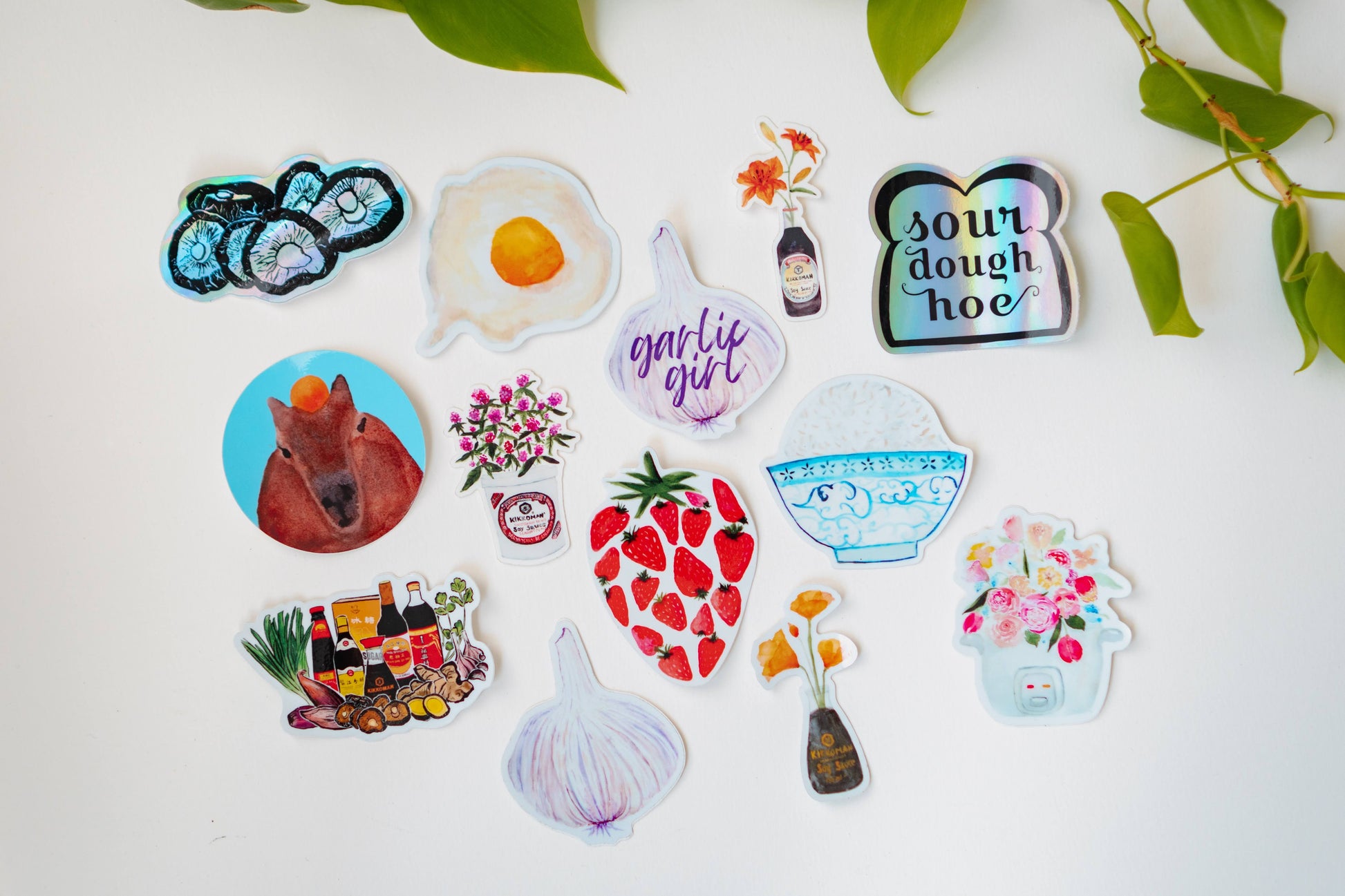 A collection of Menmin Made's thirteen food stickers, including the Capybara sticker.