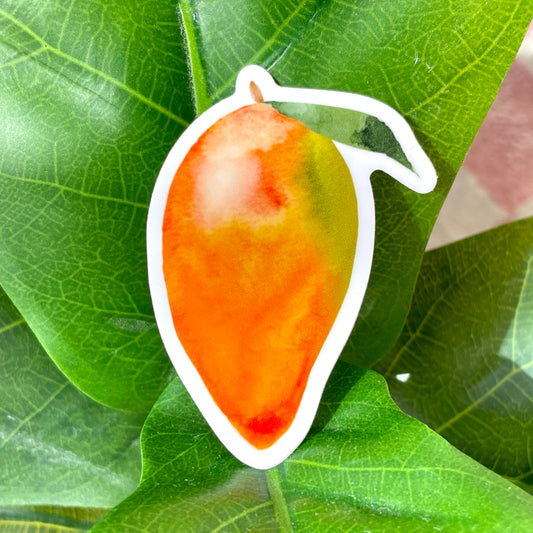 A sticker of a green and orange whole mango with a small green leaf still attached.