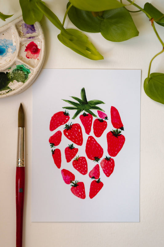 A watercolor print of several smaller, red strawberries making up one large strawberry.
