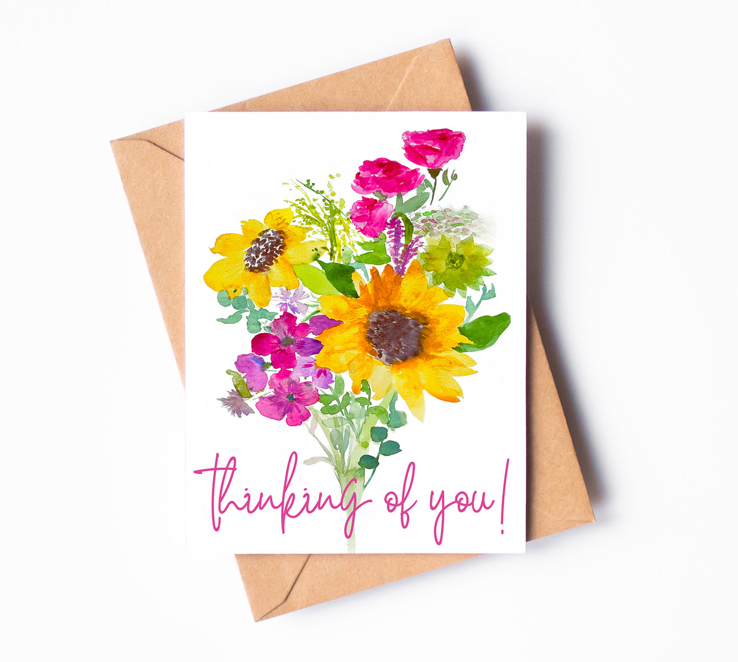 A greeting card of a cheery watercolor boquet, made of sunflowers, carnations, and other flowers. The words "thinking of you!" are written across the bottom of the card in cursive.