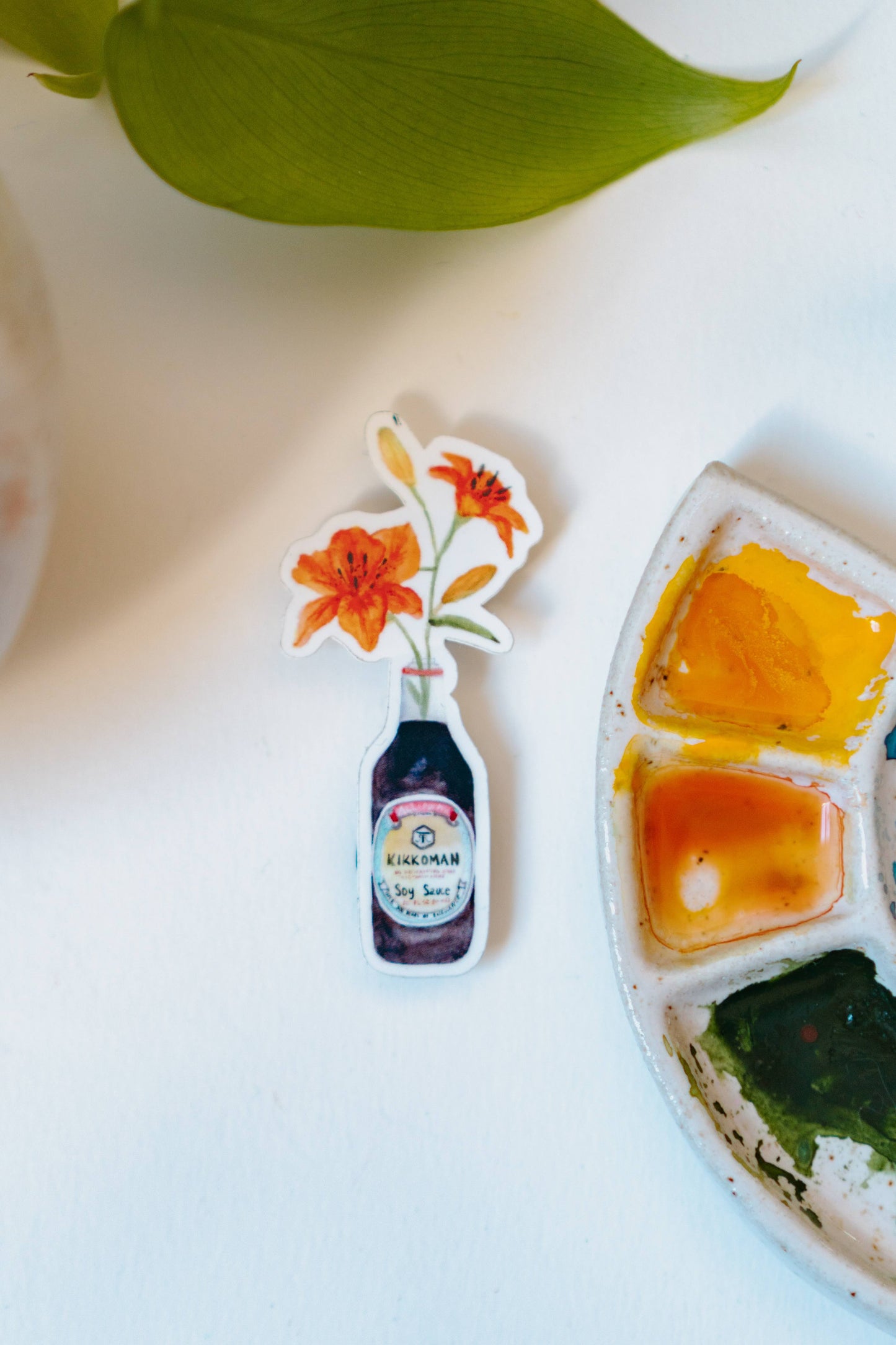 A watercolor sticker of two orange tiger lilies in a Kikkoman soy sauce bottle.