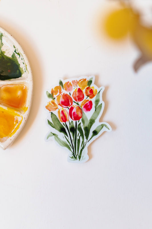 A sticker of orange and red watercolor tulips, standing on dark green stems.