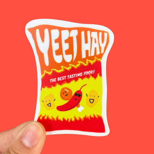A sticker of a spicy bag of chips, drawn with red-yellow flames and smiling spicy foods, including a chili with sunglasses. "Yeet Hay" is written across the top of the bag, and below is written, "The best tasting food!"