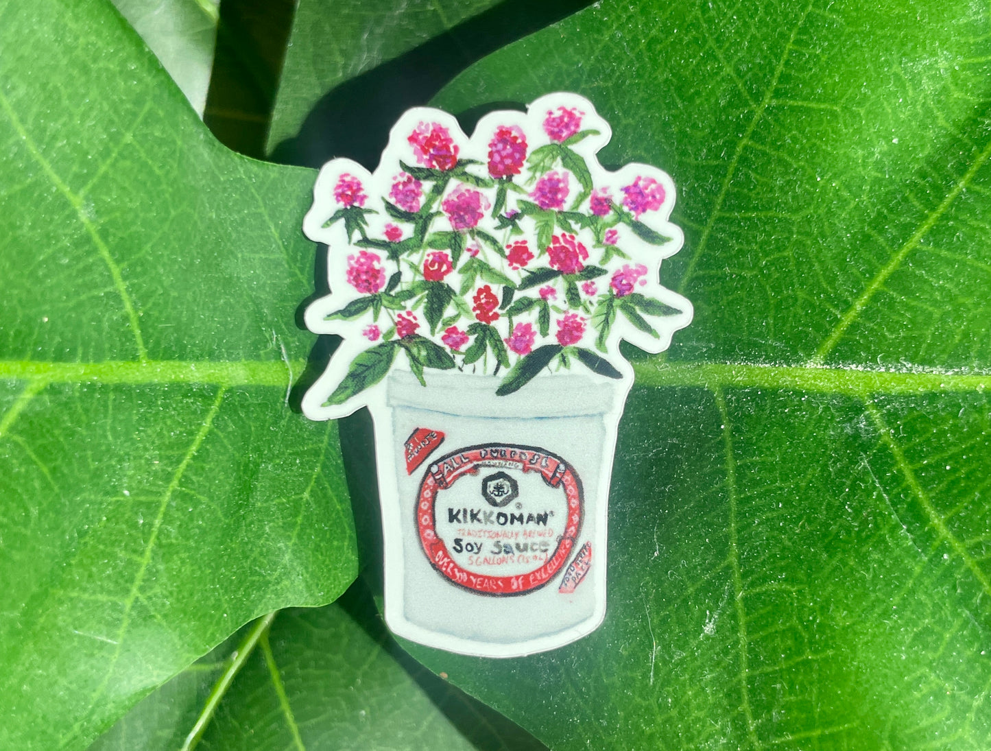 An Amaranths in Soy Sauce Sticker, depicting pink globe amaranths in a Kikkoman soy sauce bucket.