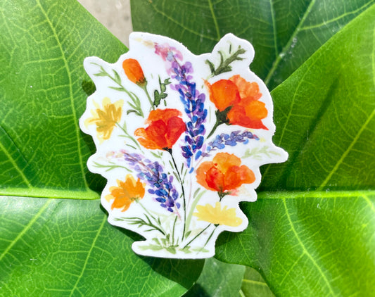 A white sticker of California poppies, California buttercups, and silver lupine.