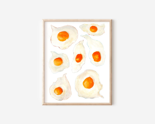 A watercolor print of seven sunny side up eggs with bright orange yorks and crispy colorful edges.