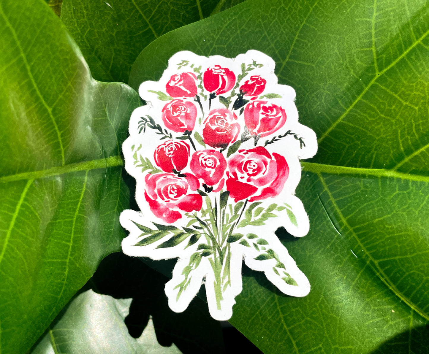A sticker depicting a watercolor bouquet of red roses and small green bunches of leaves.