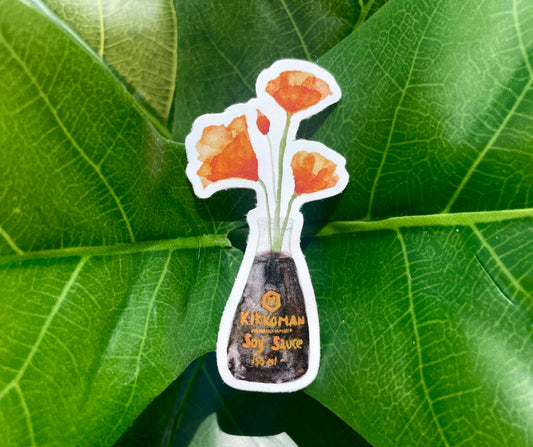 A white sticker of four orange California Poppies in a soy sauce bottle.