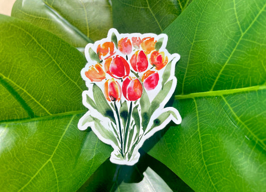 A sticker of orange and red watercolor tulips, standing on dark green stems.