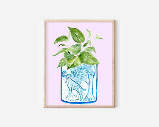 A print of a pothos plant in a blue and white porcelain vase, decorated with a goat.