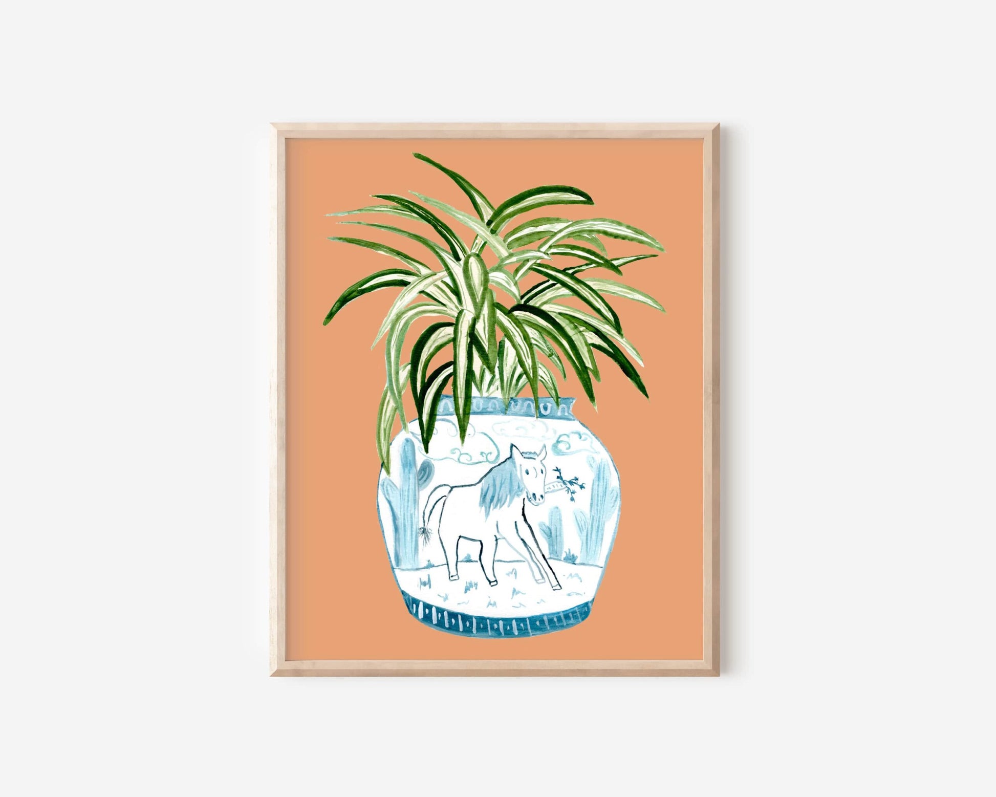 A print of a spider plant in a blue and white porcelain vase, decorated with a horse.