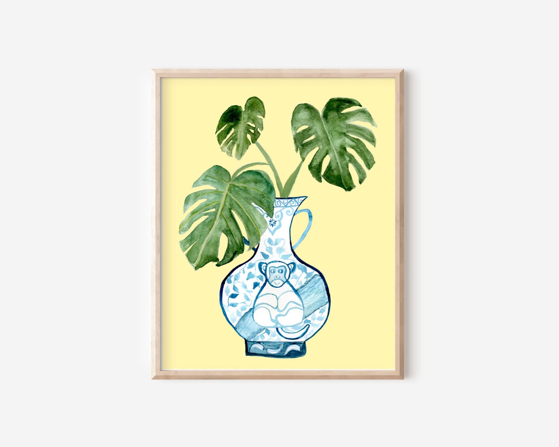 A print of a monstera plant in a blue and white porcelain vase, decorated with a monkey.