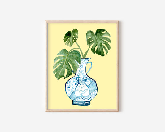 A print of a monstera plant in a blue and white porcelain vase, decorated with a monkey.