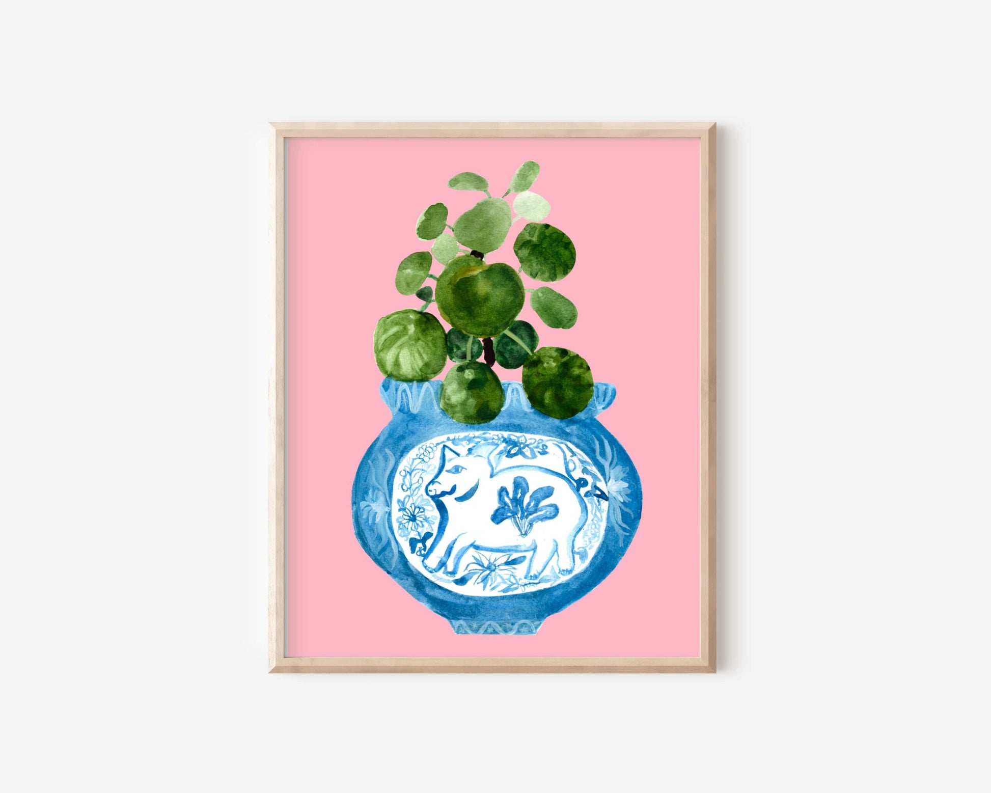 A print of a pilea plant in a blue and white porcelain vase, decorated with a pig.