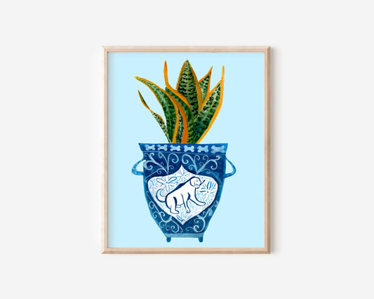 A print of a snake plant in a blue and white porcelain vase, decorated with a dog.