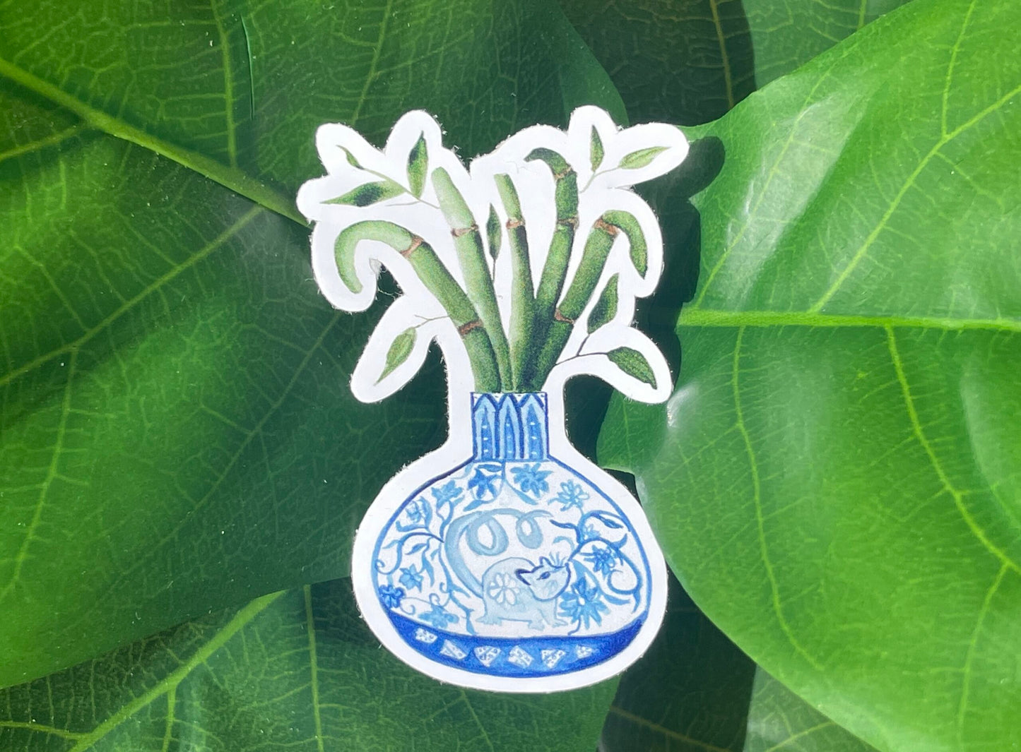 A sticker of a bamboo plant in a blue and white porcelain vase, decorated with a rat.