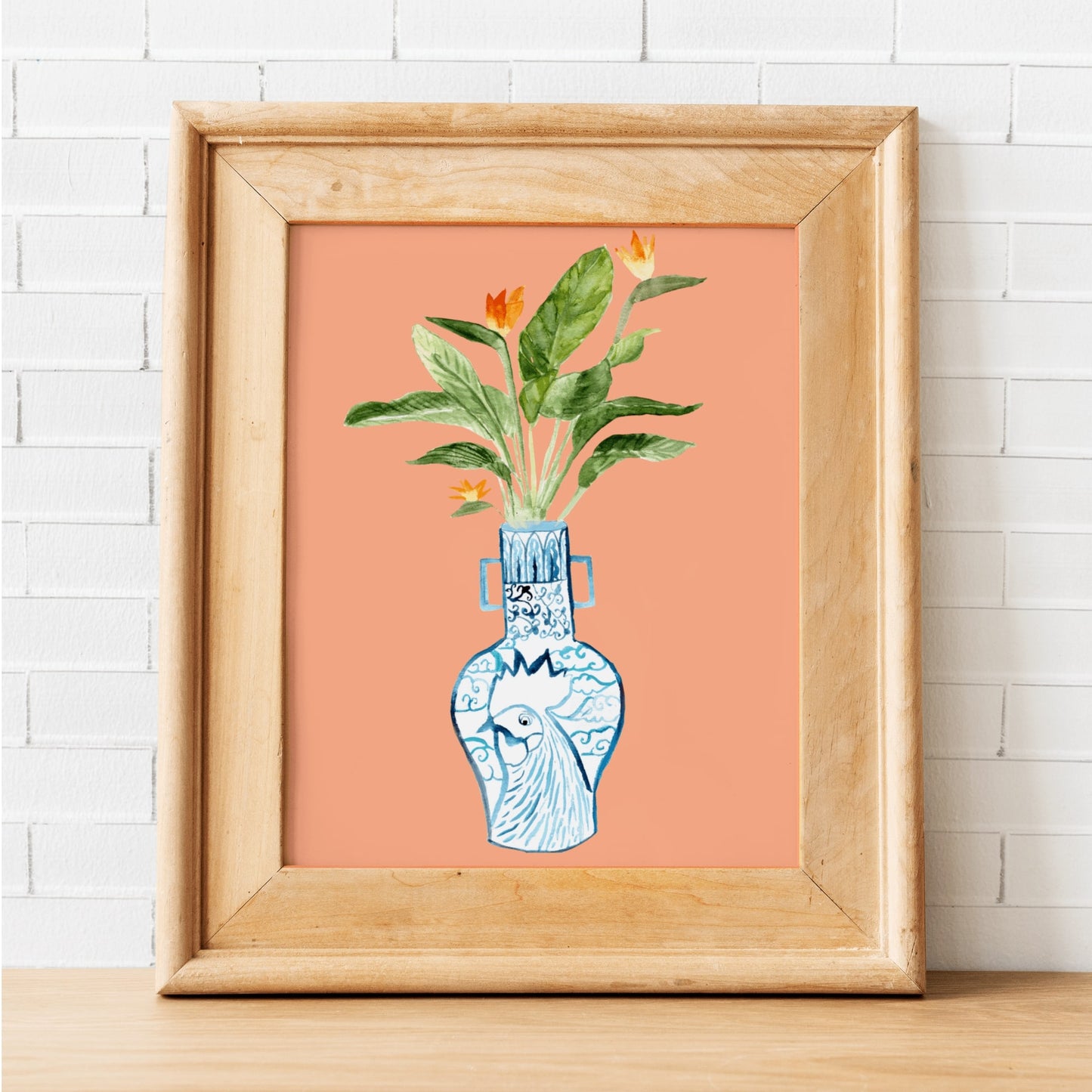 A print of a bird of paradise plant in a blue and white porcelain vase, decorated with a rooster.