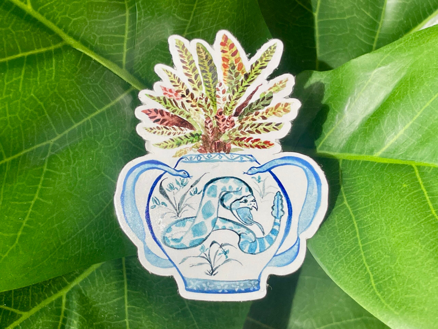 A sticker of a rattlesnake plant in a blue and white porcelain vase, decorated with a snake.