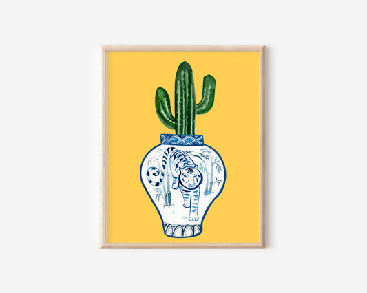 A print of a saguaro cactus in a blue and white porcelain vase, decorated with a tiger.