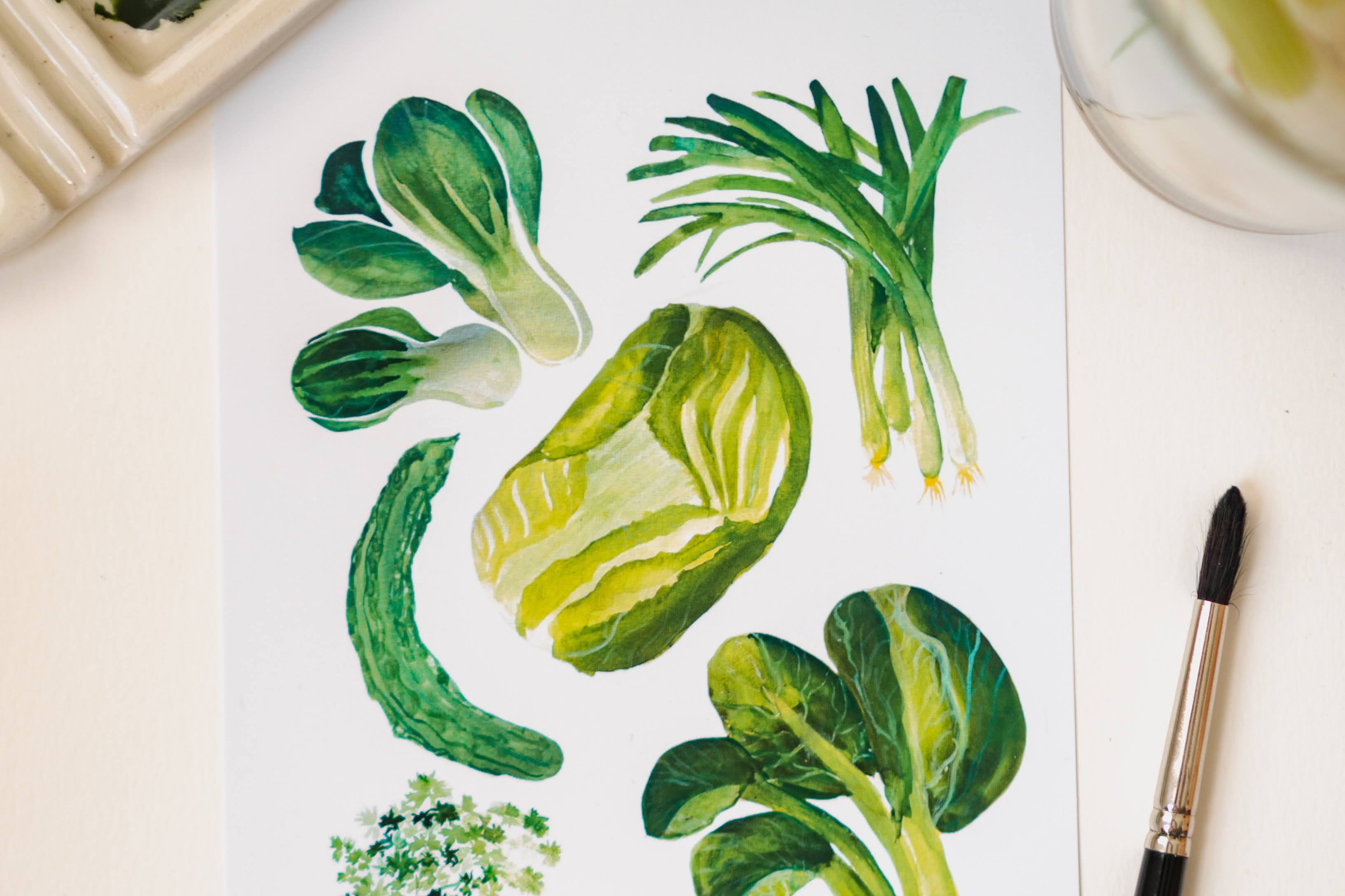A white art print depicting green Chinese vegetables: cilantro, green onion, bok choy, and napa cabbage.