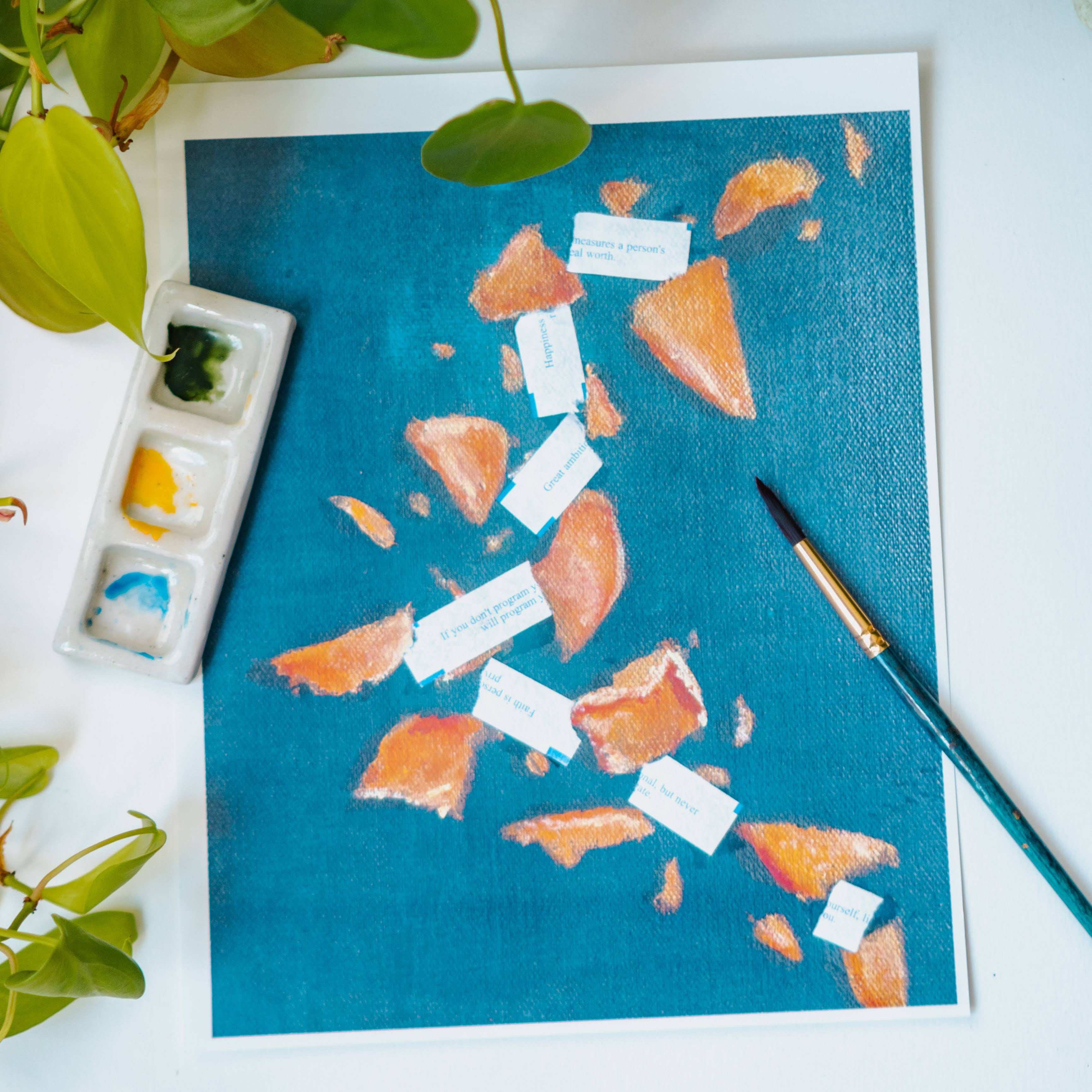 A watercolor print of broken fortune cookies and scattered fortunes on a blue background.