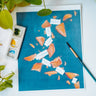 A watercolor print of broken fortune cookies and scattered fortunes on a blue background.
