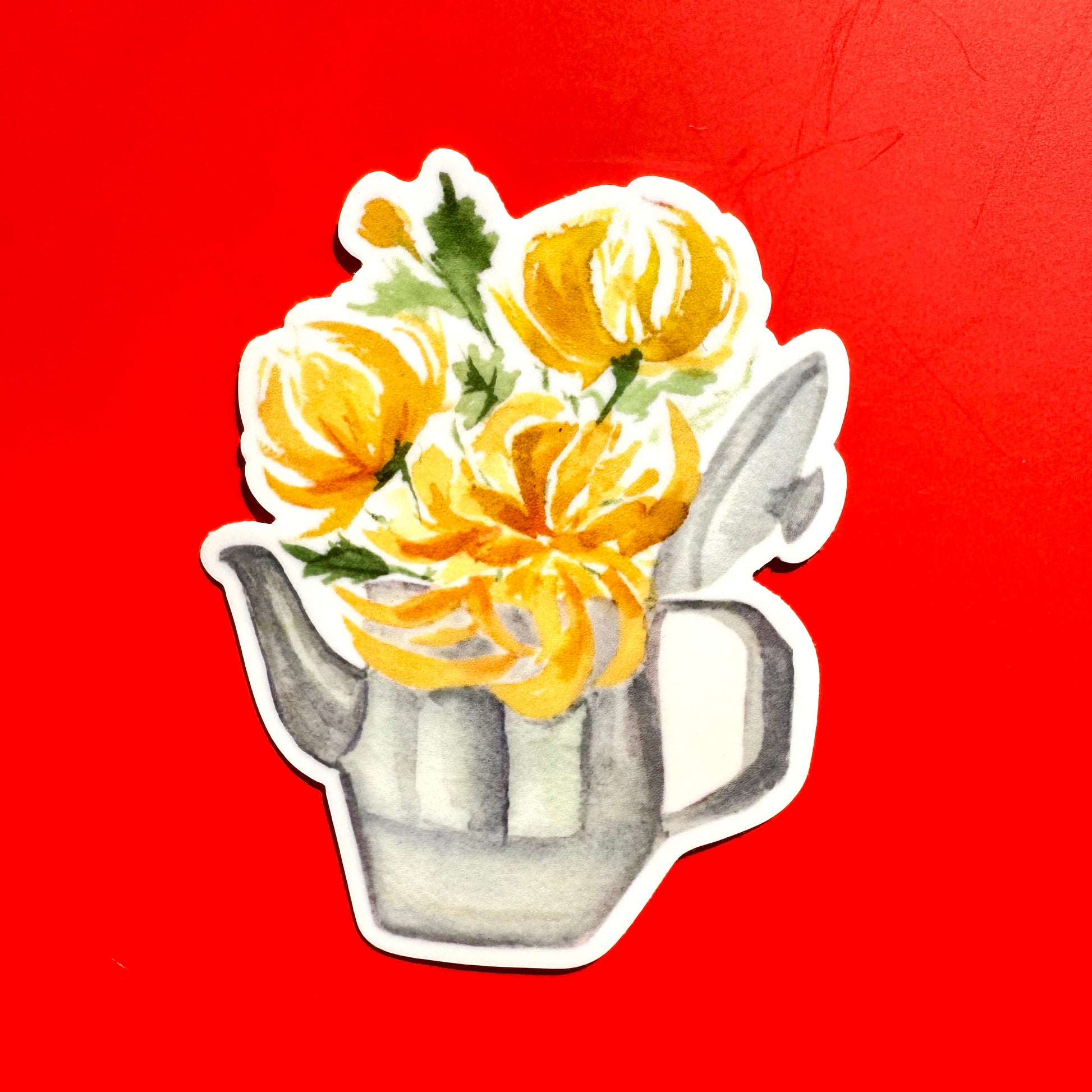 sticker of a silver teapot steeping with yellow chrysanthemum blooms