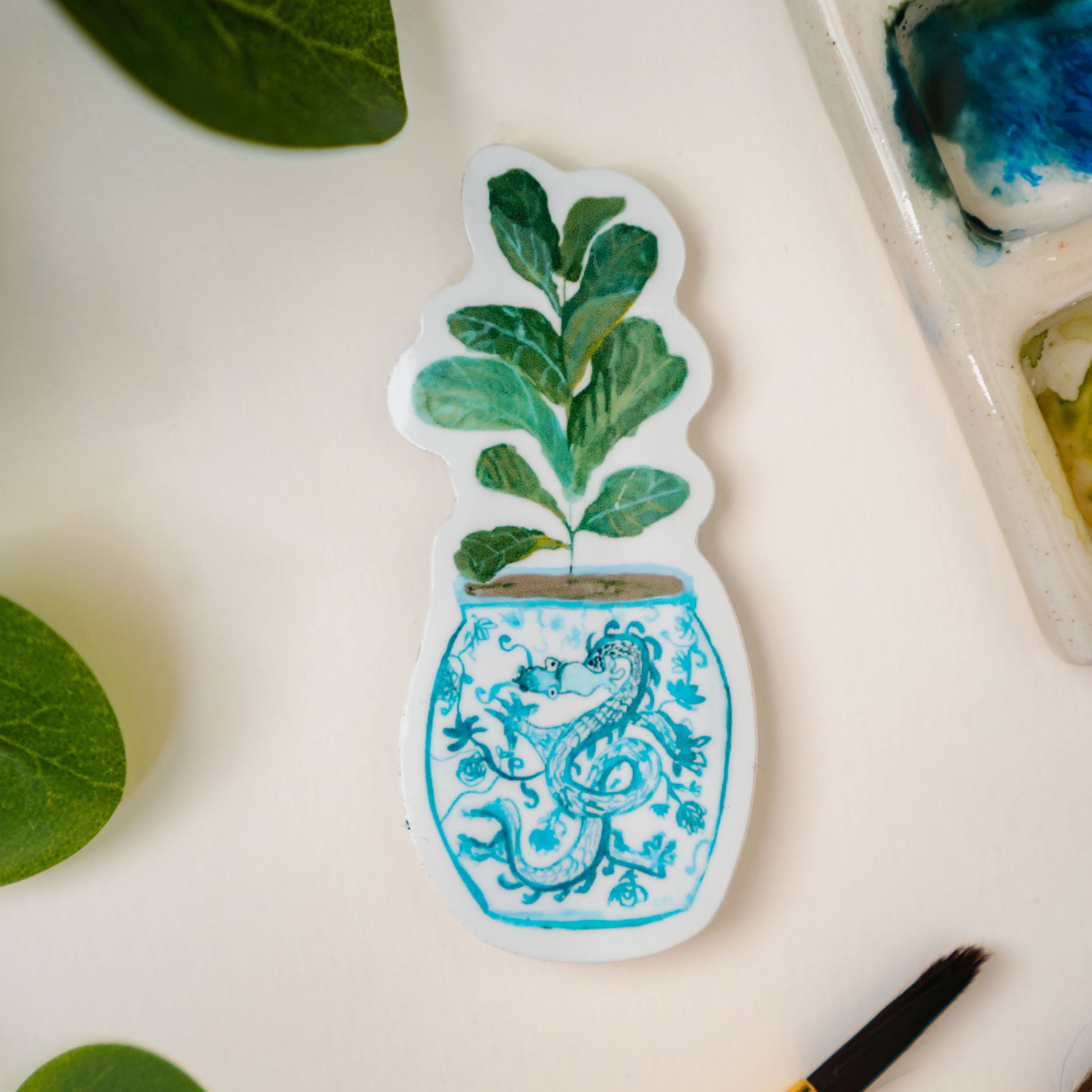 A sticker of a fiddle-leaf fig plant in a blue and white porcelain vase, decorated with a dragon.