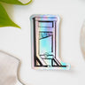 A holographic sticker of a guillotine, with the words "End Capitalism" written on the blade.