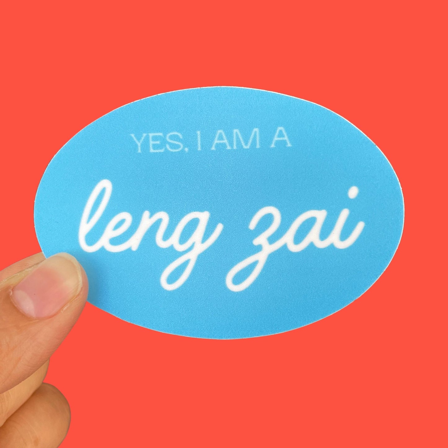 A light blue sticker with the phrase "Yes, I am a leng zai" written on it.