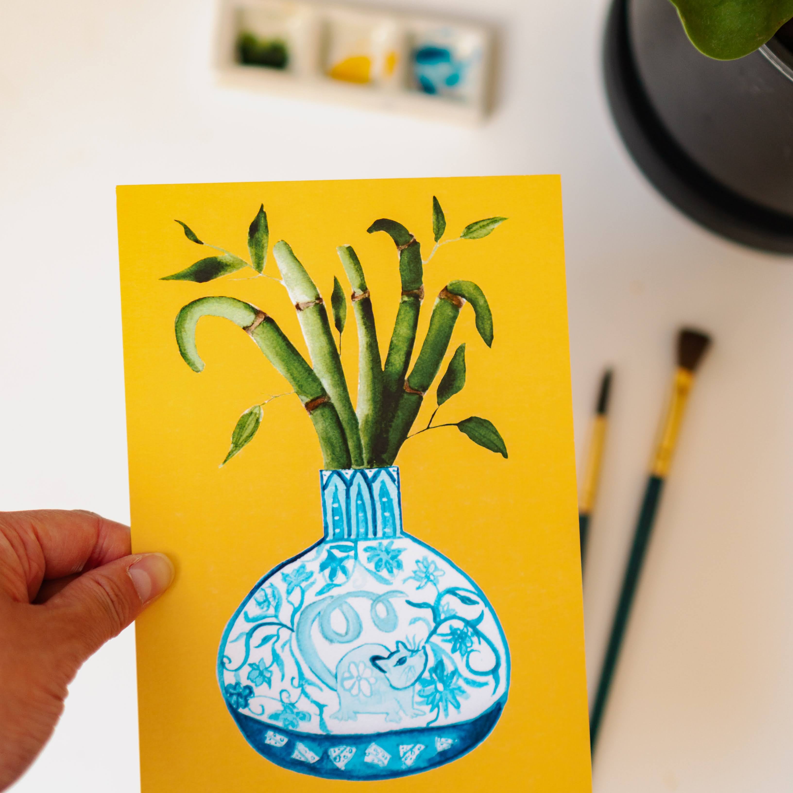 A print of a bamboo plant in a blue and white porcelain vase, decorated with a rat.