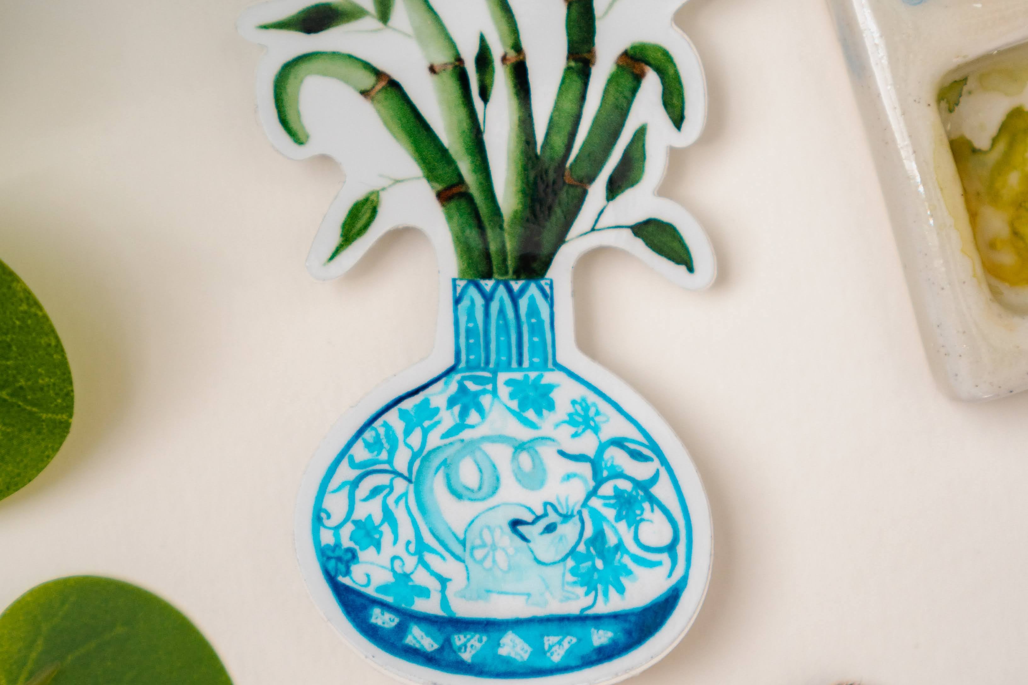 A sticker of a bamboo plant in a blue and white porcelain vase, decorated with a rat.