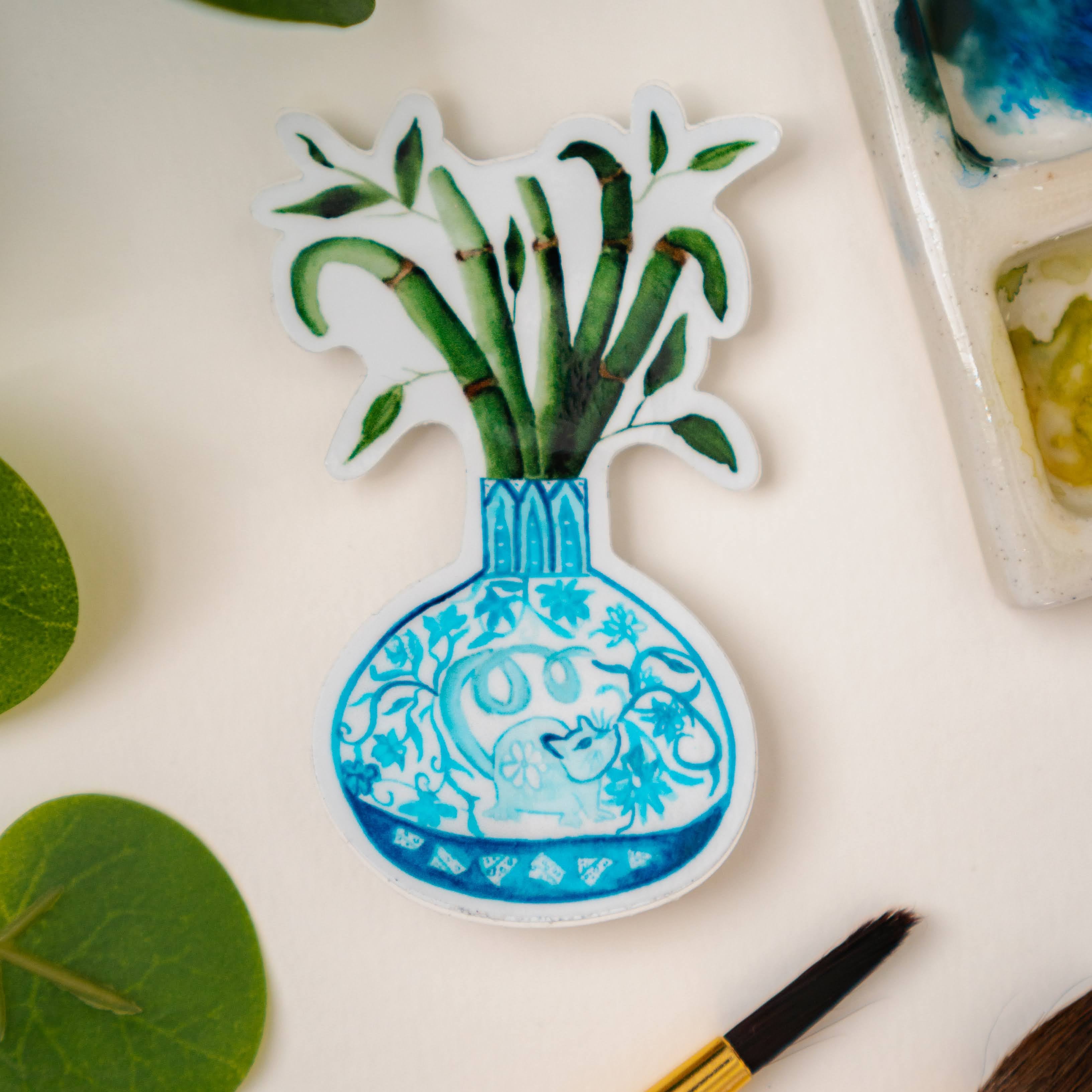 A sticker of a bamboo plant in a blue and white porcelain vase, decorated with a rat.