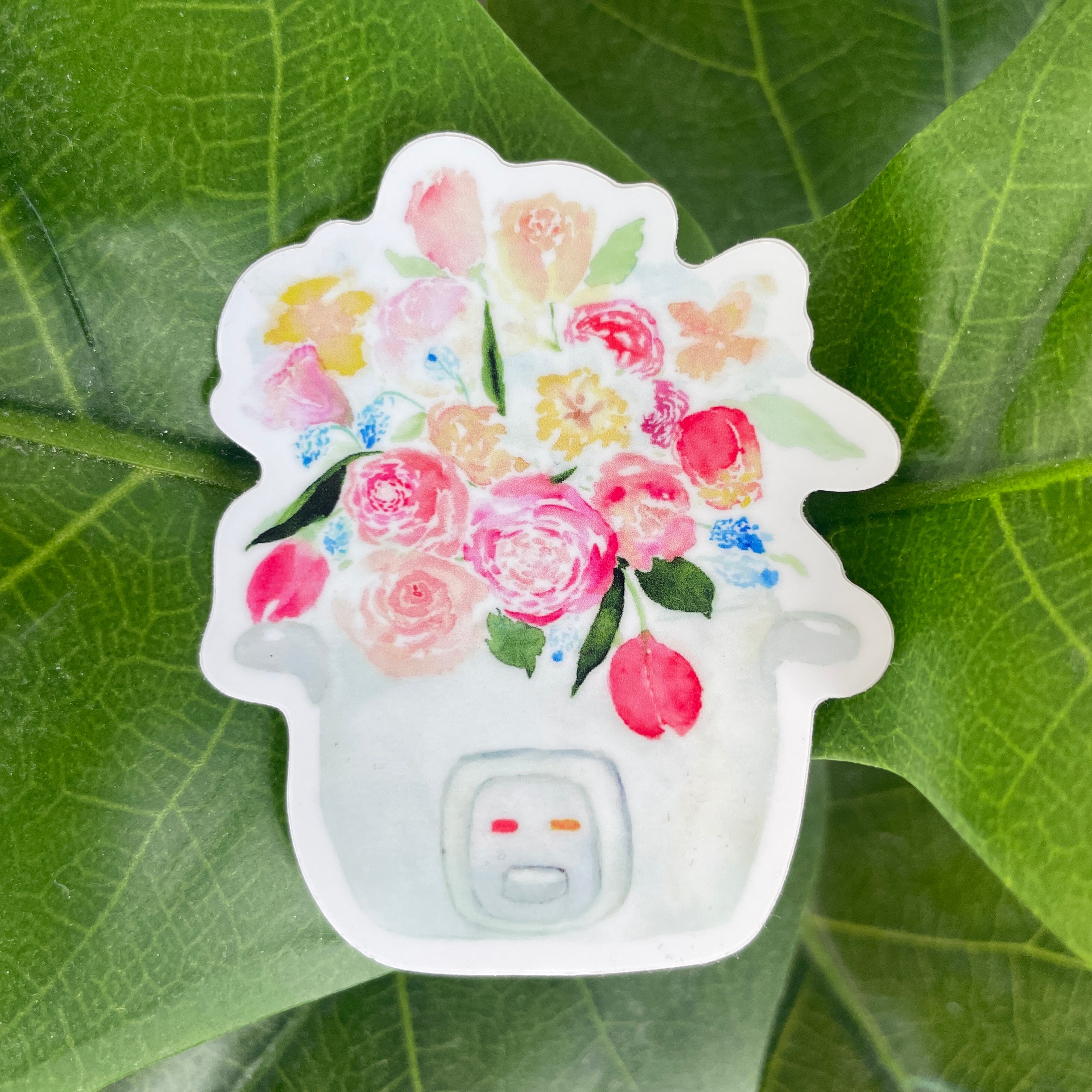 A pink, blue, and white sticker of a bouquet of tulips, roses, and other flowers sprouting out of a rice cooker.
