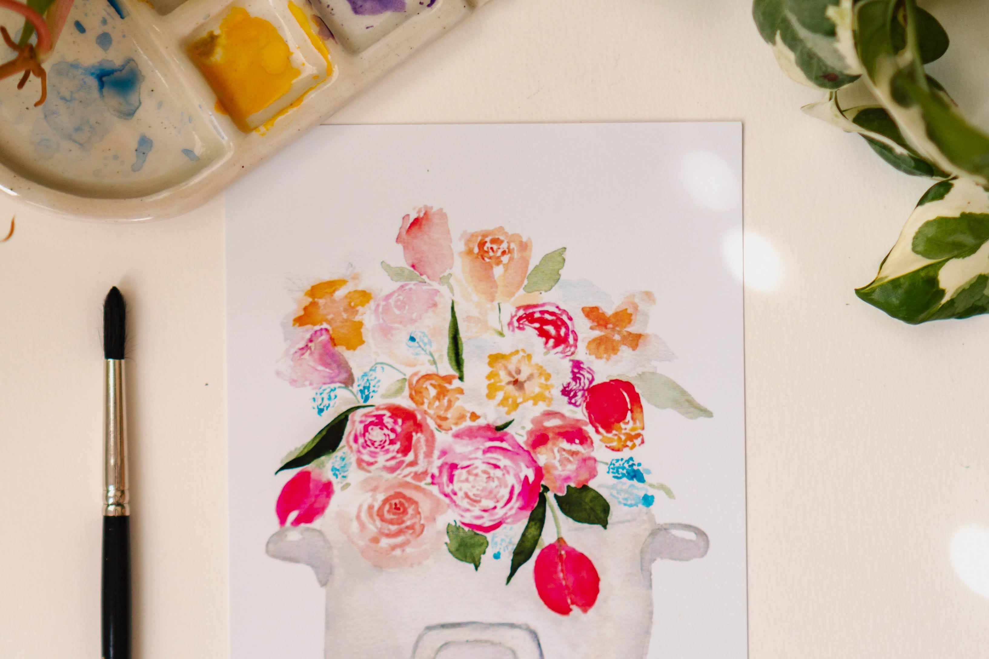 A pink, blue, and white print of a bouquet of tulips, roses, and other flowers sprouting out of a rice cooker.