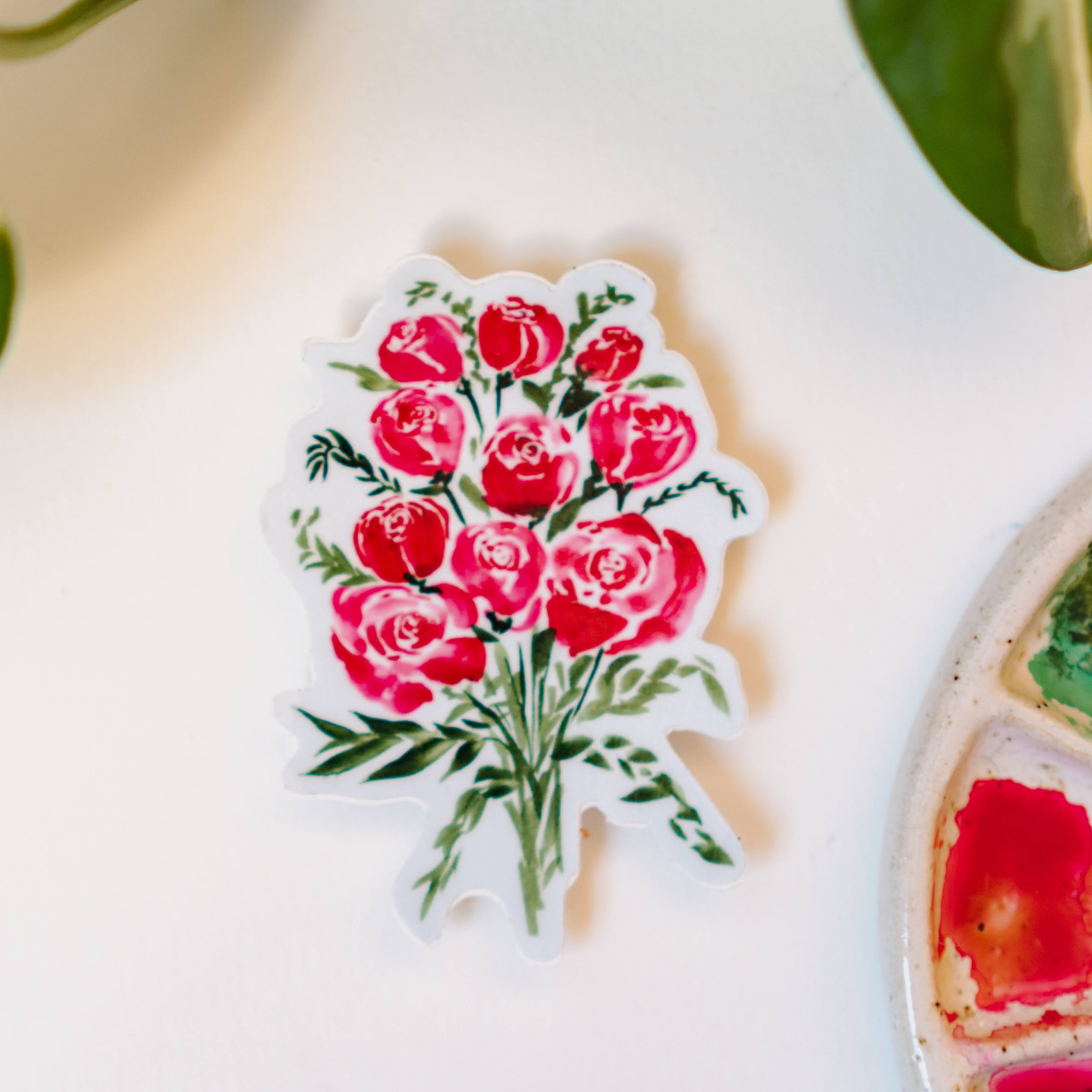 A sticker depicting a watercolor bouquet of red roses and small green bunches of leaves.