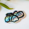 A holographic sticker featuring six shiitake mushrooms rendered in ink.