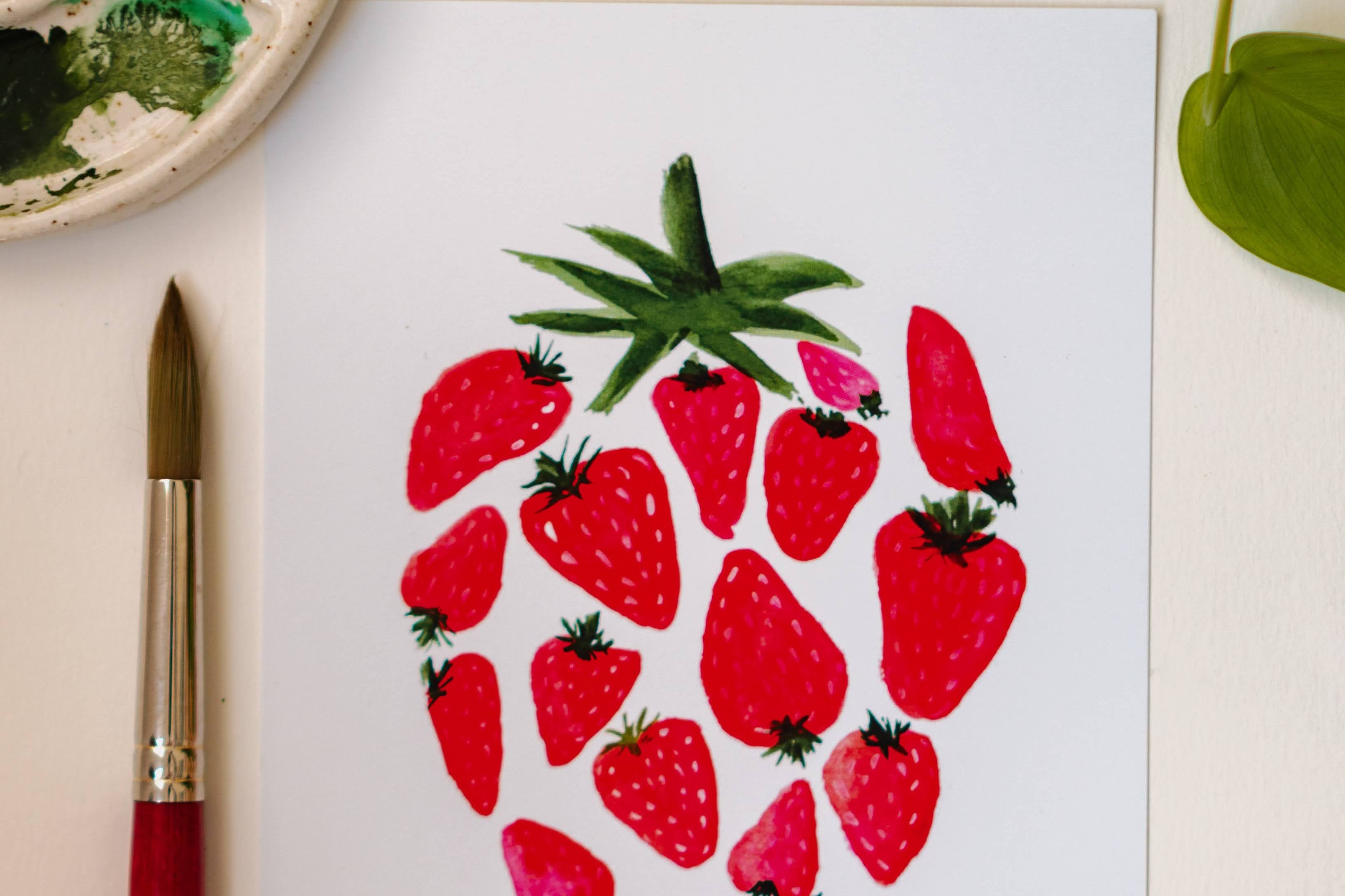 A watercolor print of several smaller, red strawberries making up one large strawberry.