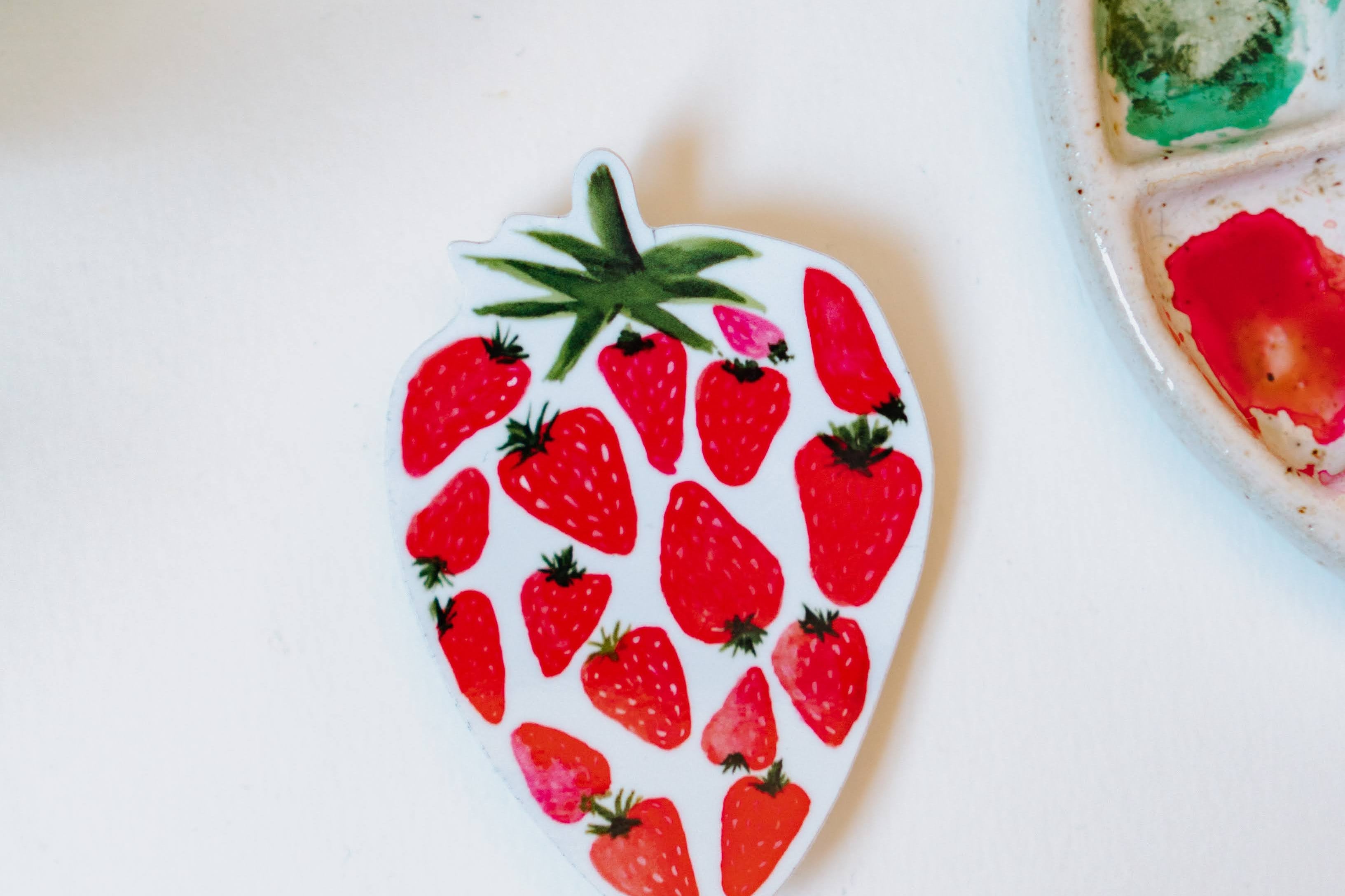 A watercolor sticker of several smaller, red strawberries making up one large strawberry.