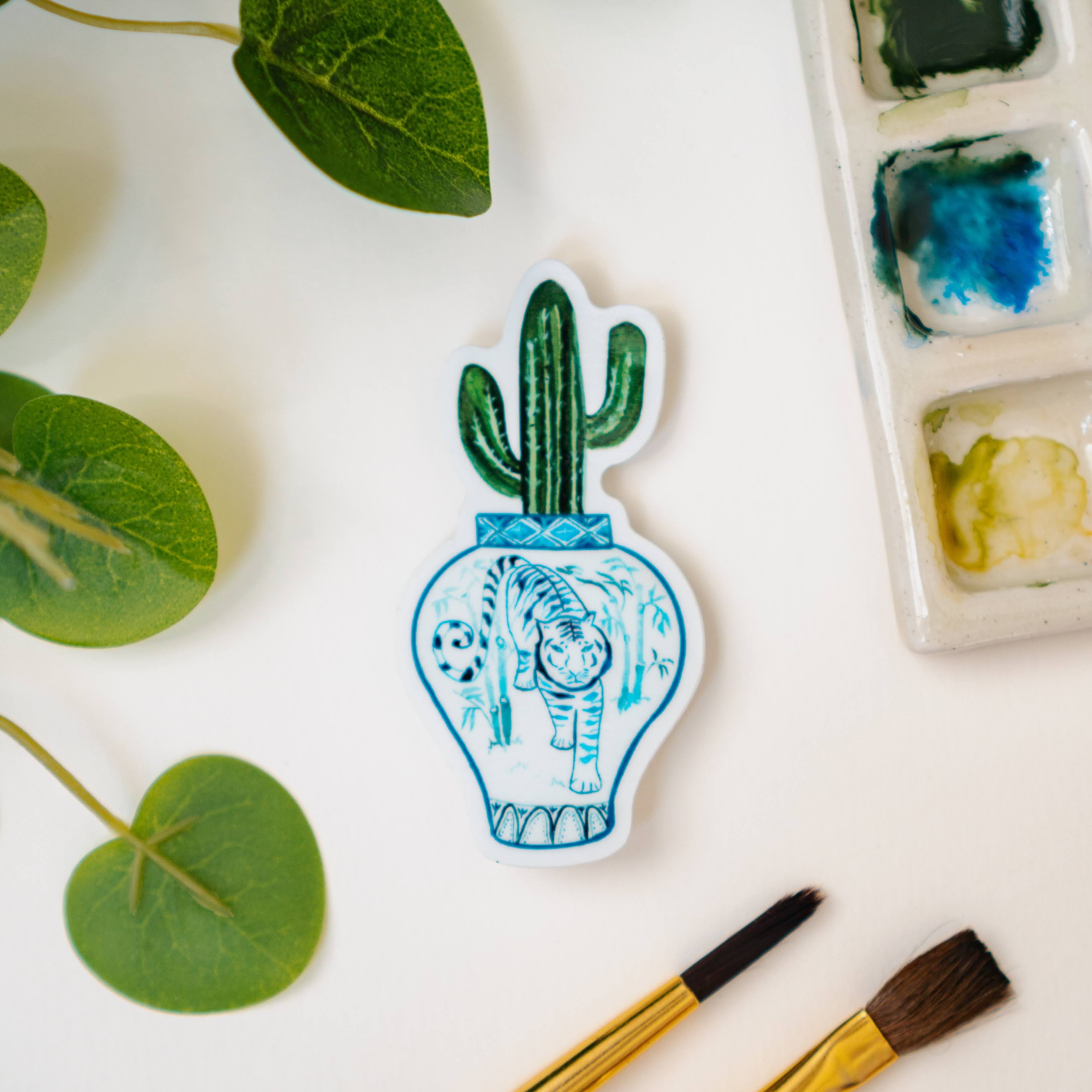 A sticker of a saguaro cactus in a blue and white porcelain vase, decorated with a tiger.