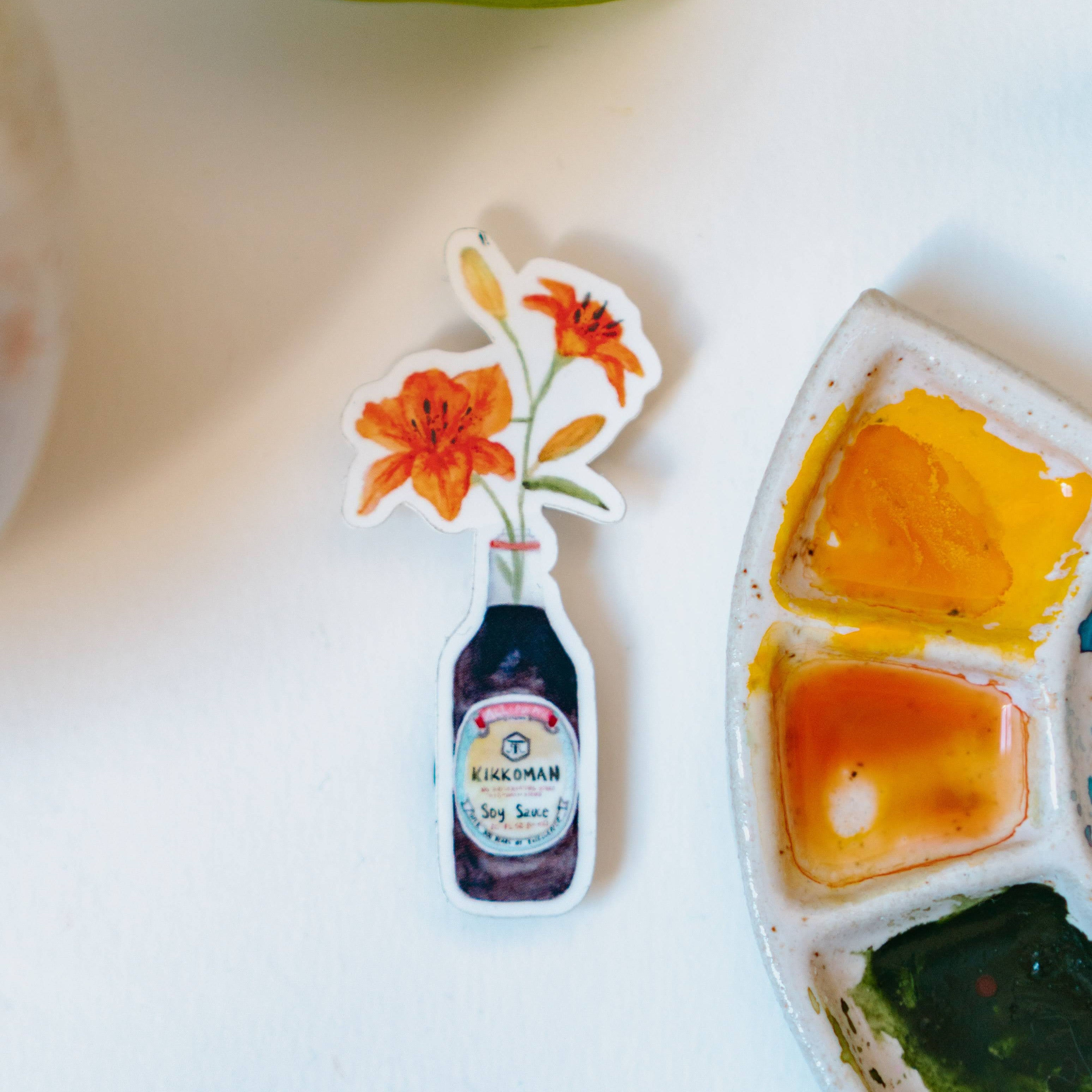 A watercolor sticker of two orange tiger lilies in a Kikkoman soy sauce bottle.