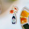 A watercolor sticker of two orange tiger lilies in a Kikkoman soy sauce bottle.