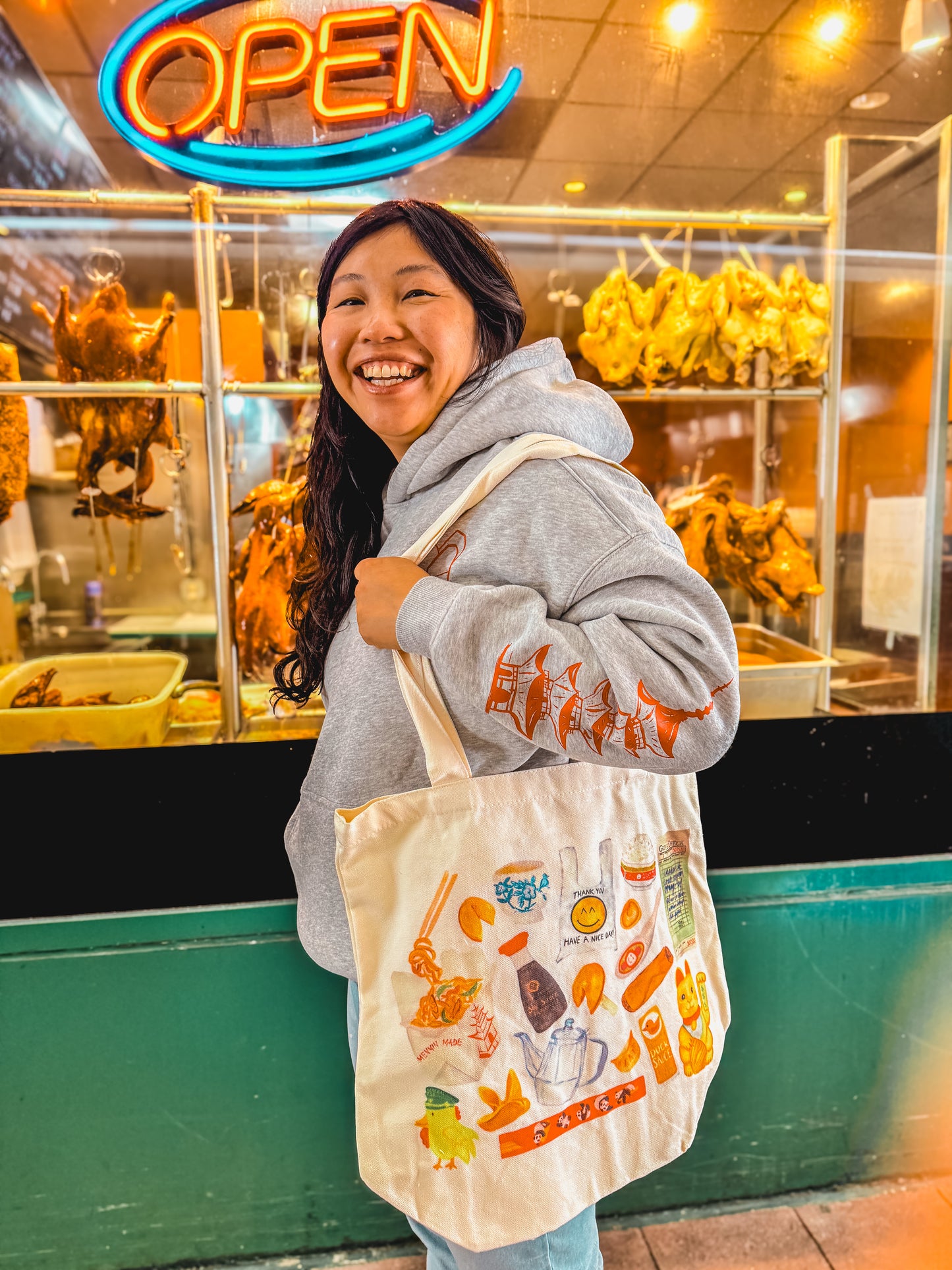 women smiling carrying a tote bag with watercolor of classic Chinese takeout restaurant items