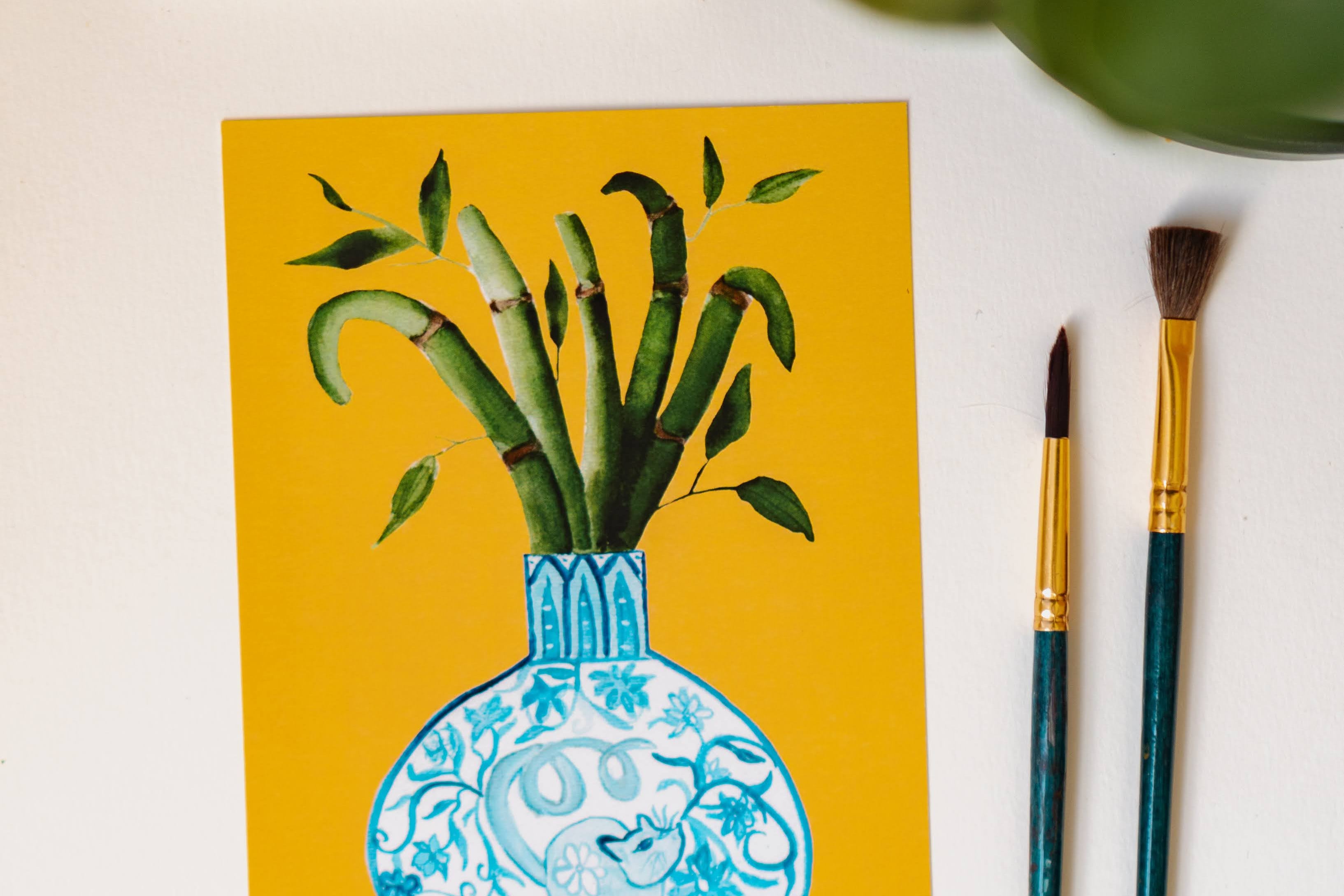 A print of a bamboo plant in a blue and white porcelain vase, decorated with a rat.