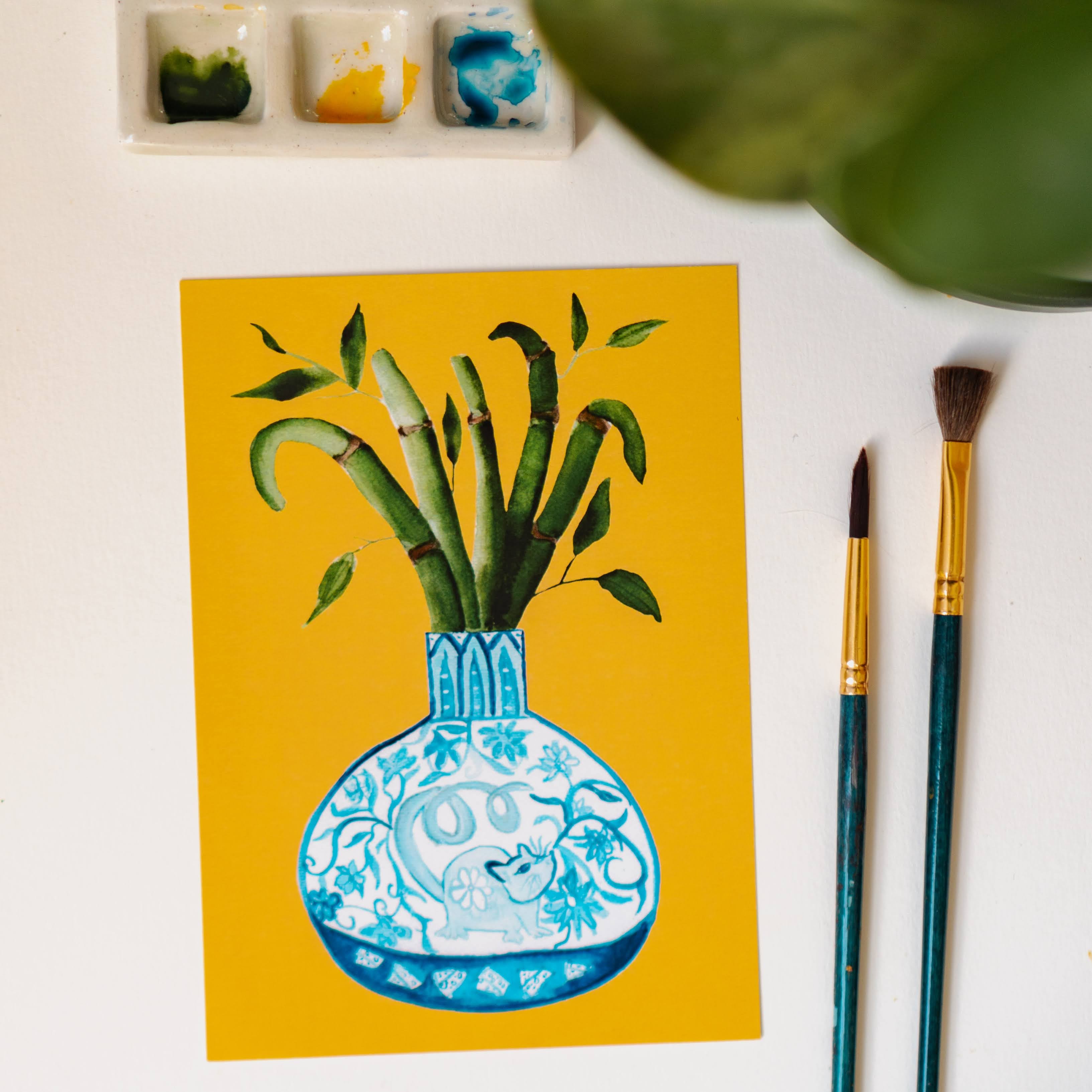 A print of a bamboo plant in a blue and white porcelain vase, decorated with a rat.