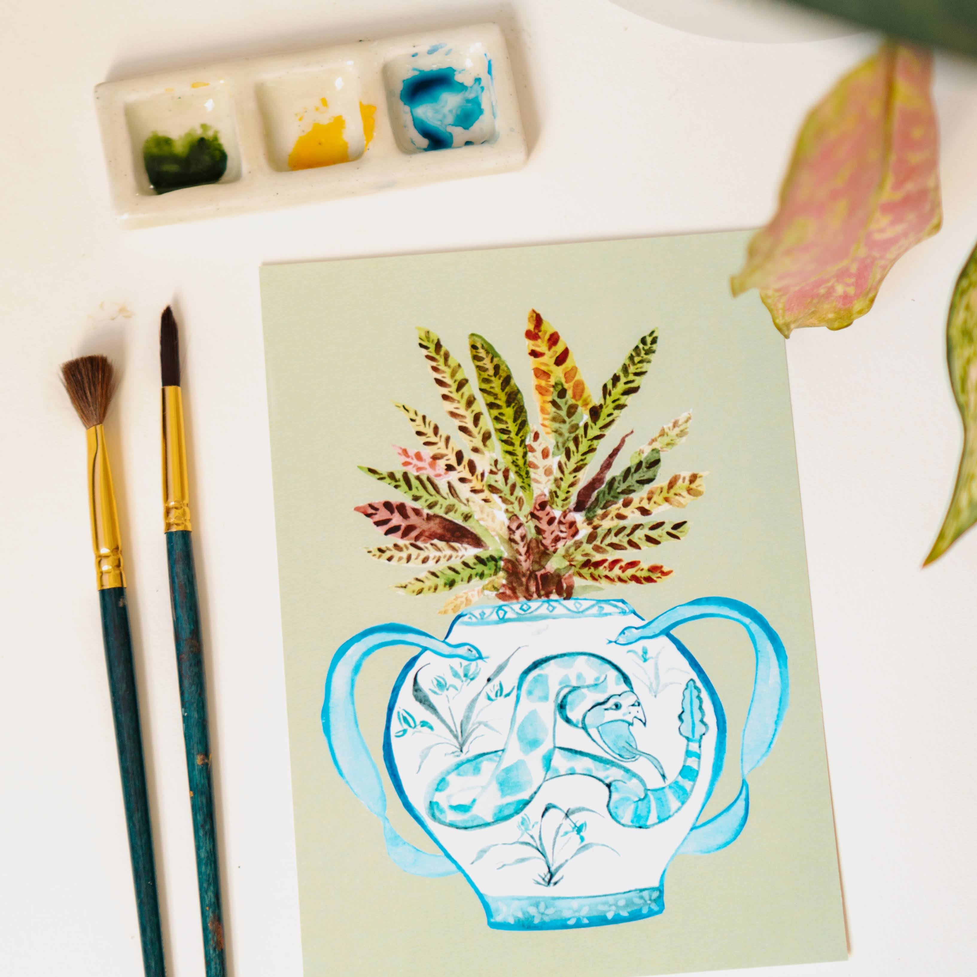 A print of a rattlesnake plant in a blue and white porcelain vase, decorated with a snake.