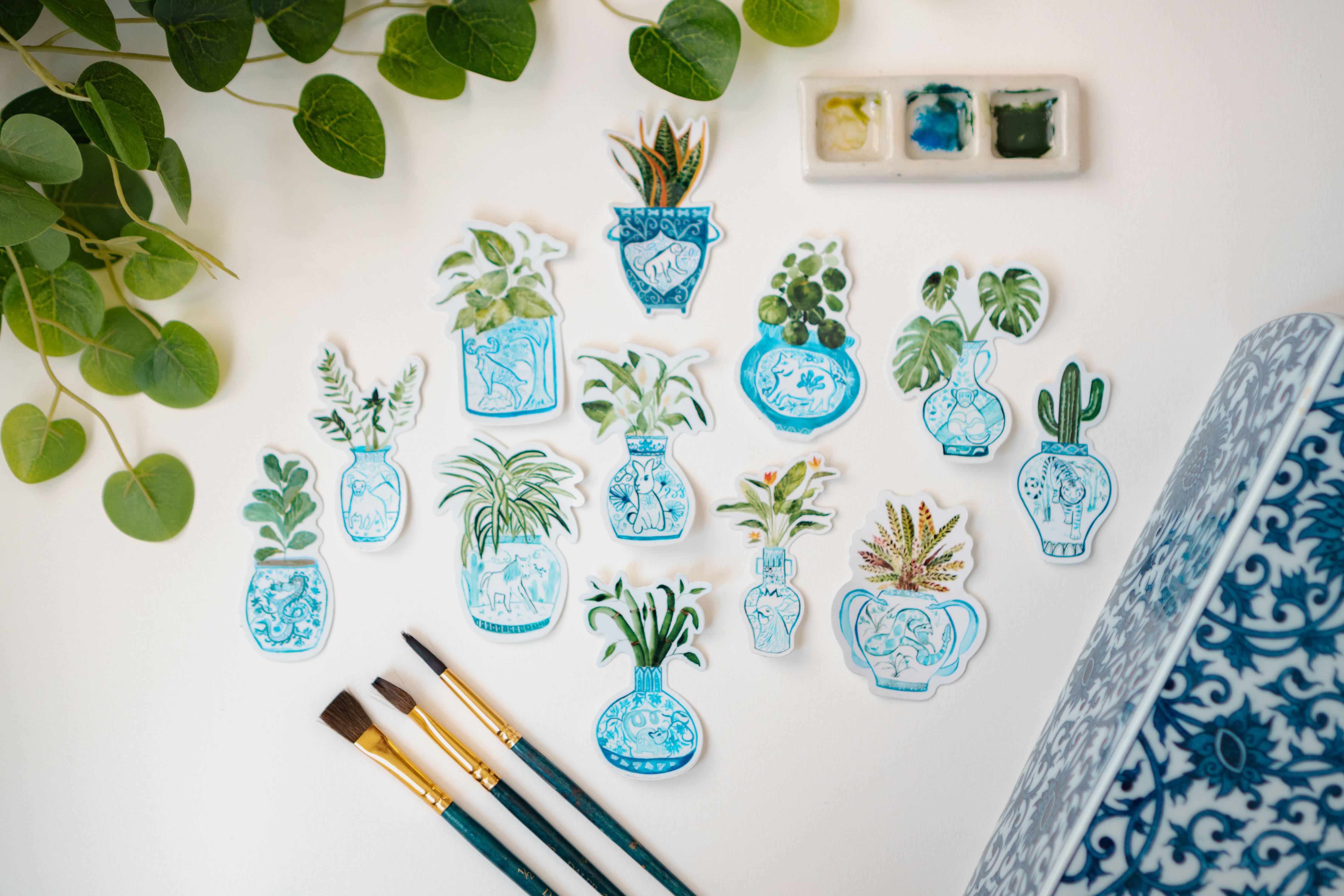 A collection of Menmin Made's Zodiac Plant stickers, including the Year of the Tiger + Saguaro Cactus Sticker.
